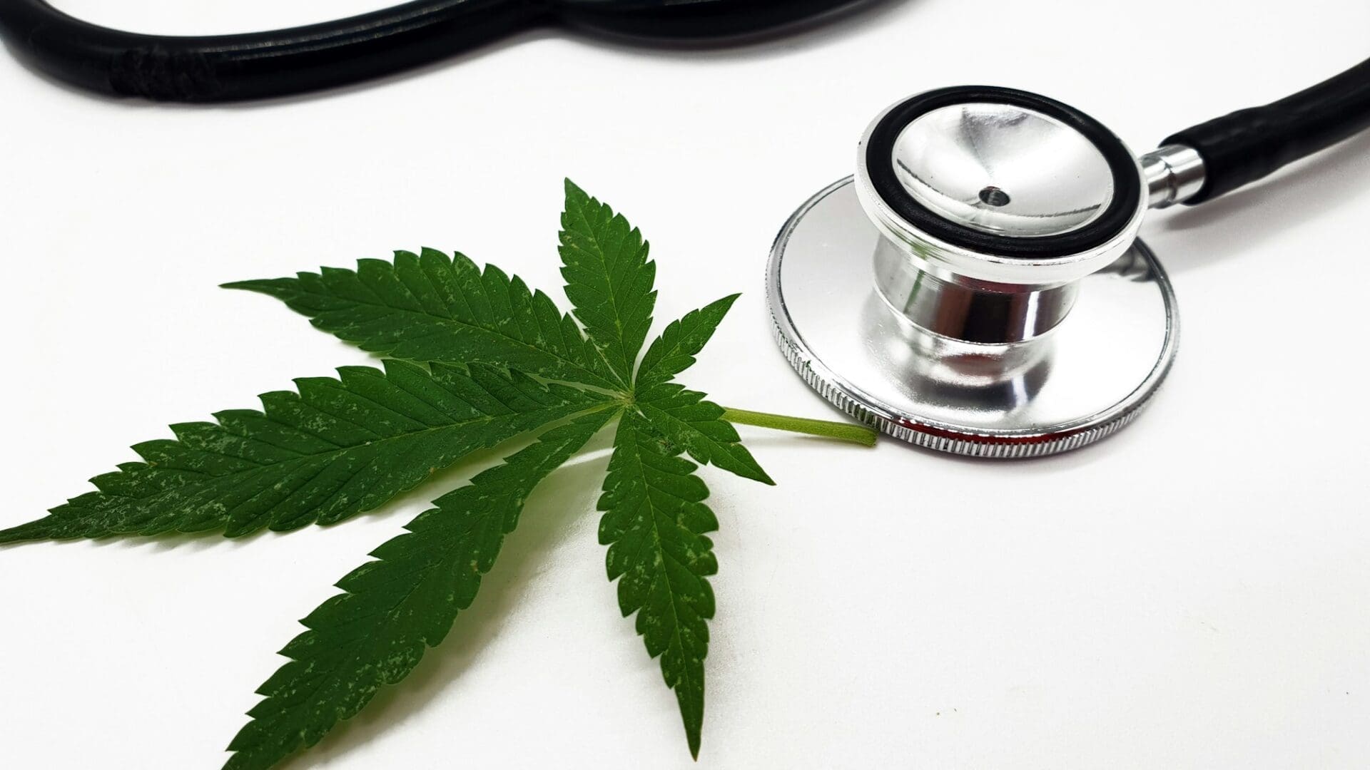 Closeup of a stethoscope with cannabis isolated on a white background