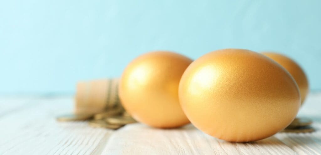 Golden eggs and money on against blue background, space for text